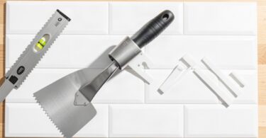 Carreaux de crédence, spatule crantée et croisillons prêts pour poser du carrelage mural soi-même