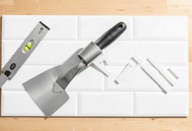Carreaux de crédence, spatule crantée et croisillons prêts pour poser du carrelage mural soi-même