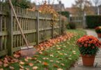 Jardin en automne avec feuilles mortes et râteau, prêt pour les travaux de saison